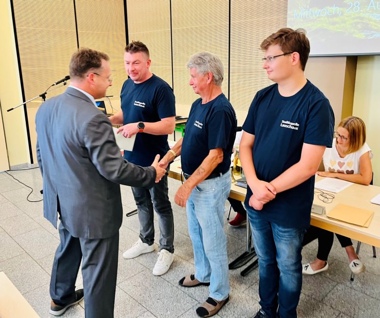 Landrat Robert Sesselmann (l.) gratuliert den Vertretern der Stadtkapelle Lauscha zur verdienten Würdigung mit dem Kulturförderpreis des Landkreises Sonneberg 2024